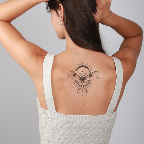 Tatouage papillon et lune réaliste et mystique pour femme dans le dos
